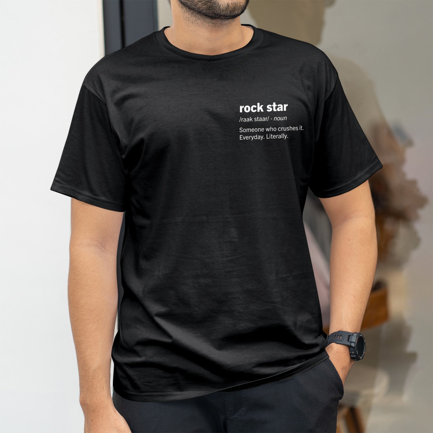 Rockstar definition on left side of chest in bold white font on black shirt.