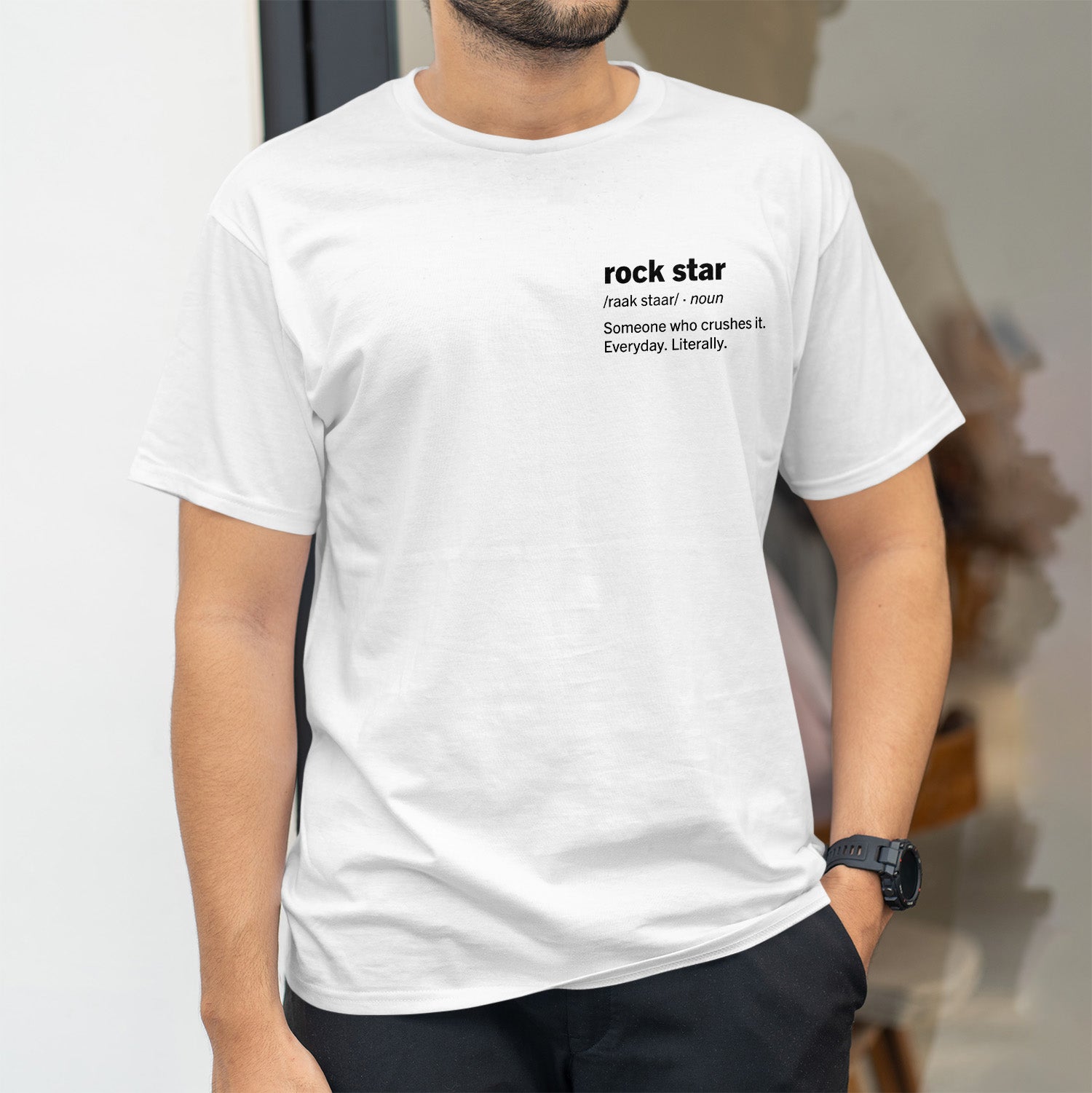 Rockstar definition on left side of chest in bold black font on white shirt.